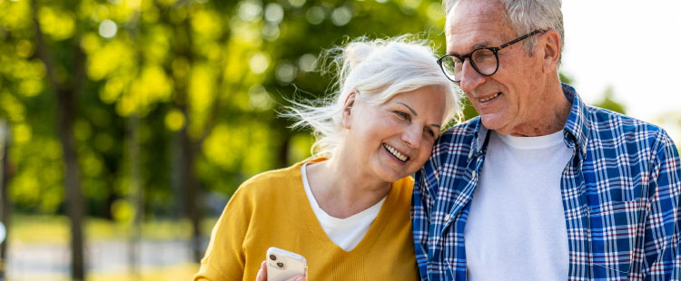 Two seniors walk together at a senior living community