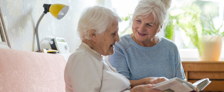 Two senior women read together