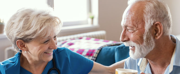 A senior man and woman smile at one another