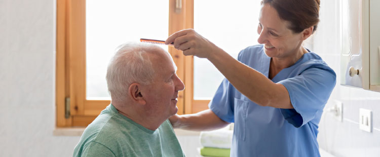 A senior man receives a haircut