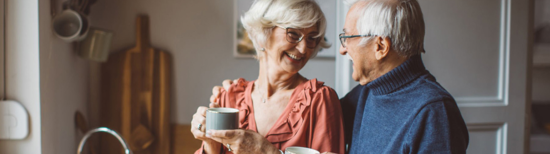 Two seniors enjoy coffee at home